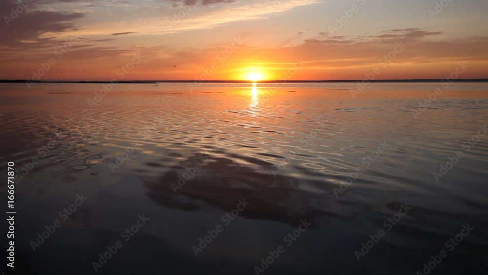 Colorful sunset over calm lake water surface Colorful sunset over calm lake water surface