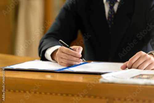 business man signing contract document in office