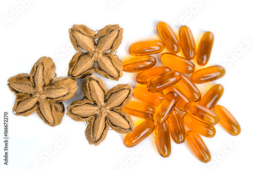 Plukenetia volubilis, sacha peanut, or sacha inchi with soft gels capsules on white background, herb and nature photo