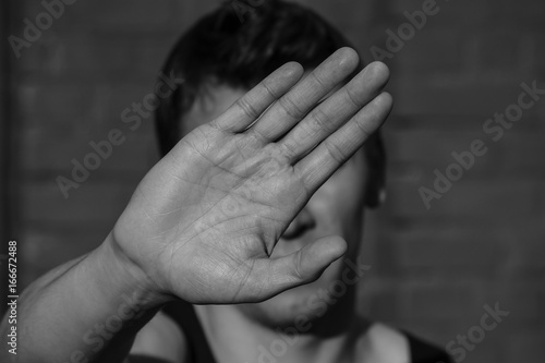 a young man covers his face with hand