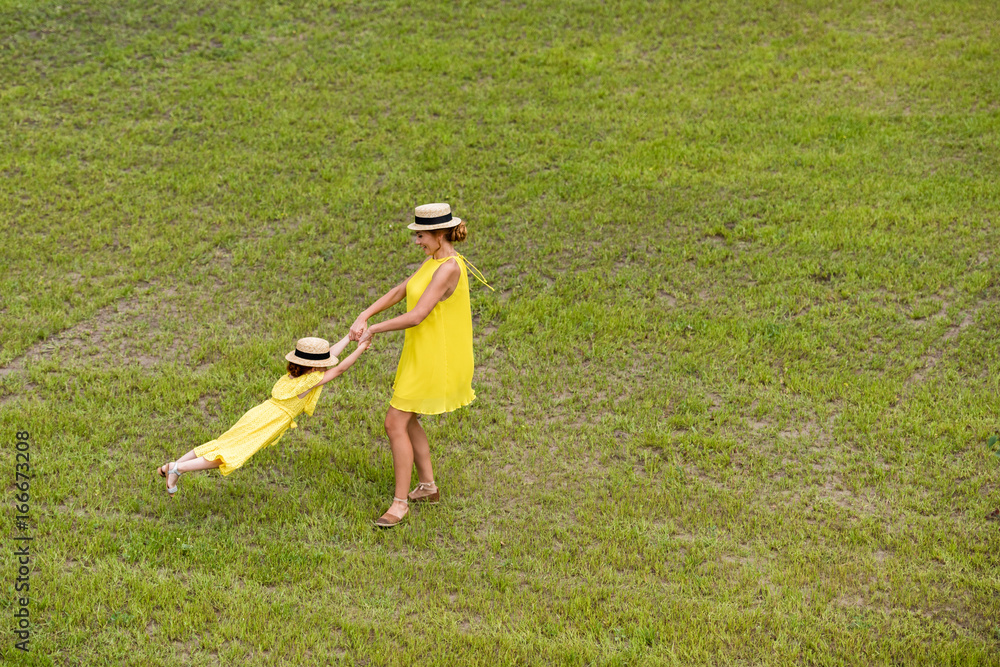 mother and daughter walking on lawn mother and daughter walking on lawn