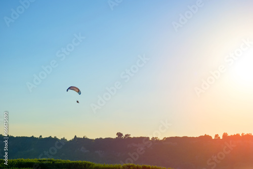 Silhouette of paraglider and evening sky