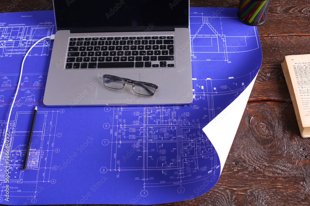 Naklejka premium Architectural blueprints and blueprint rolls and a drawing instruments on the worktable