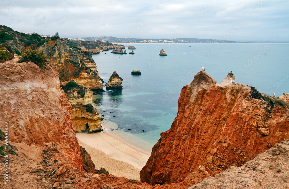Beach near Lagos is sheltered by picturesque cliffs, Algarve, Portugal.
