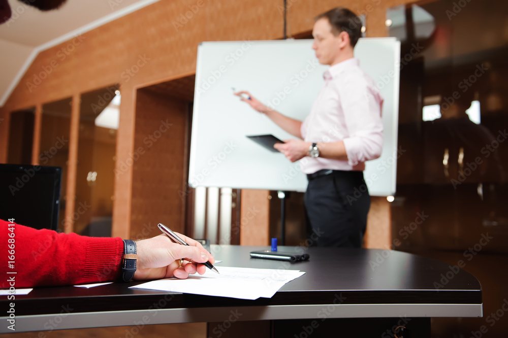 Businessman explaining business plan to coworkers in conference room. Businessman explaining business plan to coworkers in conference room.