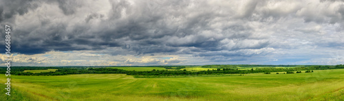 Sky with clouds over a green field. Panorama