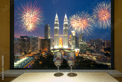 Canvas Print Closeup of a glasses of red wine at windowsill, against night Kuala lumpur city view of urban city sky line blurring lights