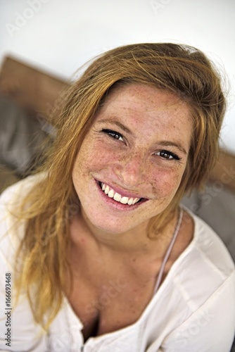 Portrait of laughing strawberry blonde young woman with freckles