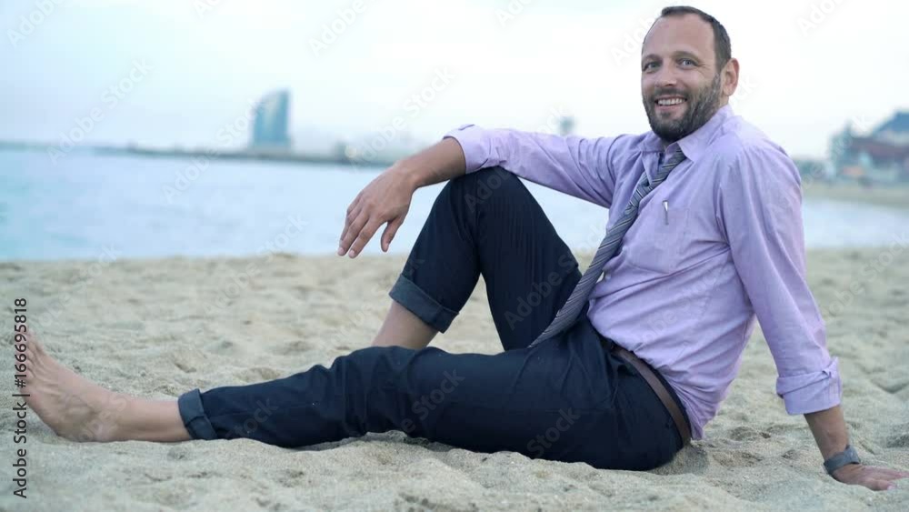 Portrait of happy, successful businessman sitting on beach
Portrait of happy, successful businessman sitting on beach