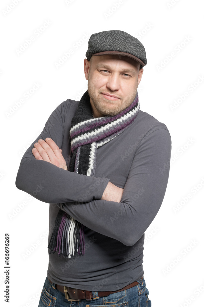 A man in a gray cap and gray scarf with arms folded. Isolated. A man in a gray cap and gray scarf with arms folded. Isolated.