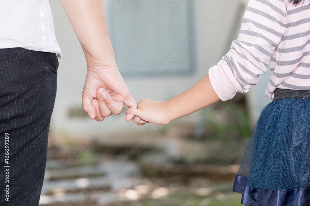 Mother and daughter holding hand in hand
