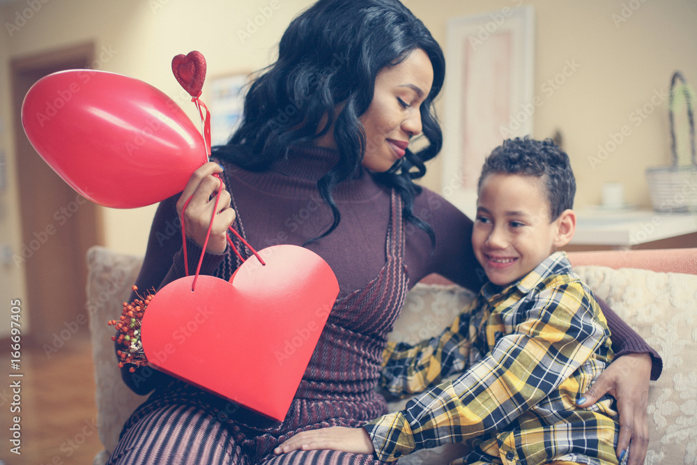 African American woman wit her son. African American boy giving a bouquet of flowers to his mother. African American woman wit her son. African American boy giving a bouquet of flowers to his mother.