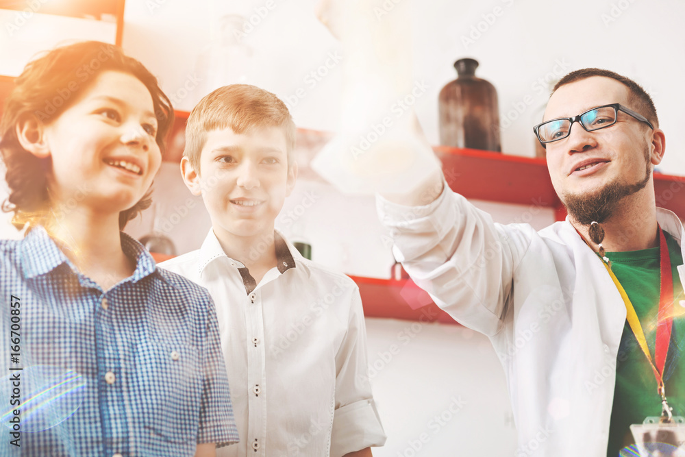 Positive delighted boys watching interesting experiment Positive delighted boys watching interesting experiment