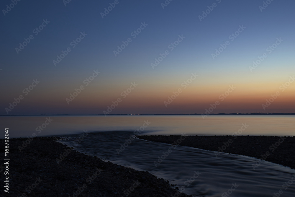  Silence and a beautiful view over the fjord from Vadum beach in Denmark at midnight - one hour after sunset           