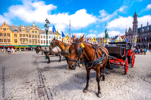Horse carriages on Grote Markt square in medieval city Brugge at morning, Belgium. photo
