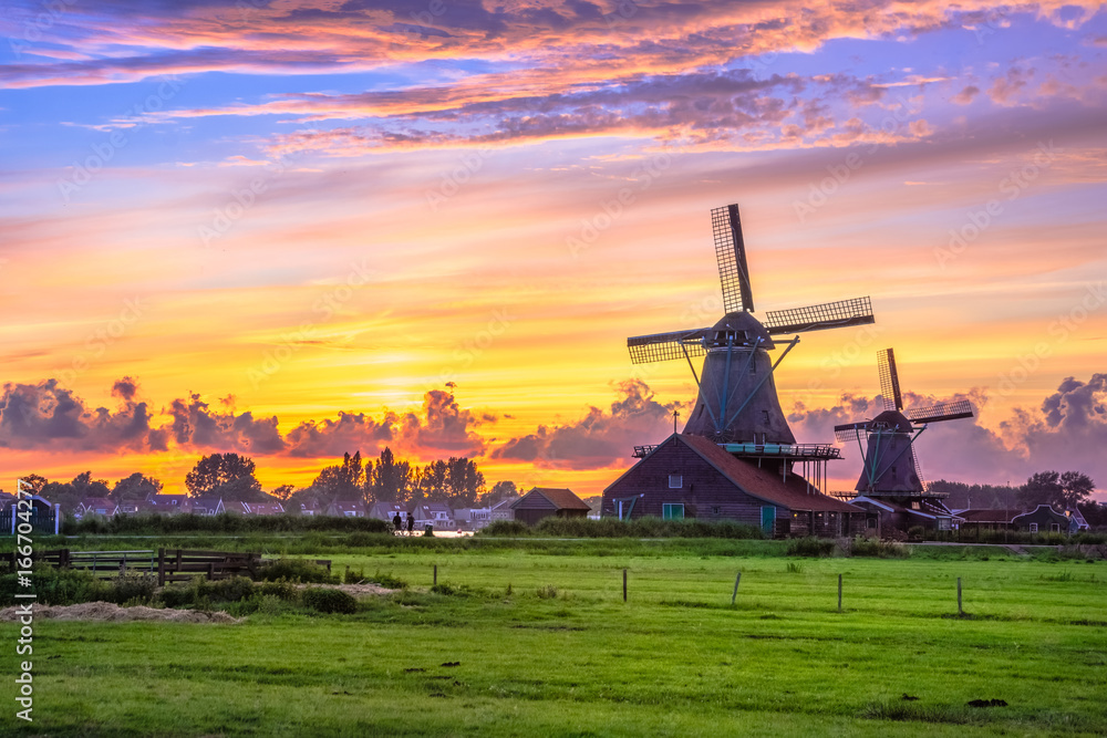 Traditional village with dutch windmills and river at sunset, Holland, Netherlands. - obrazy, fototapety, plakaty 
