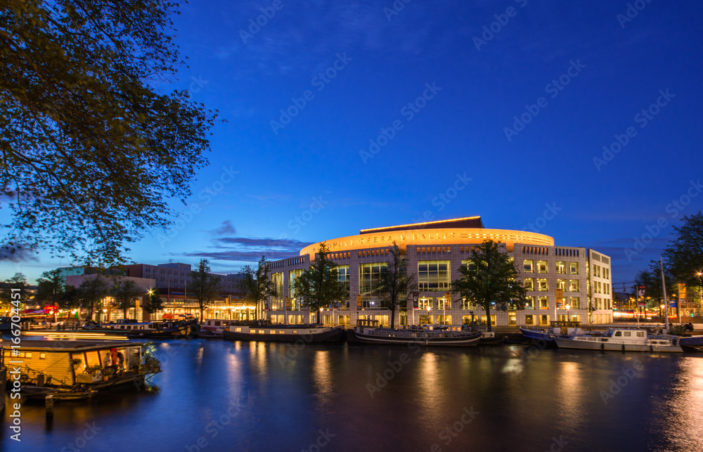 Fototapeta premium Amsterdam at night, with flowers and bicycles on the bridge, Holland, Netherlands.