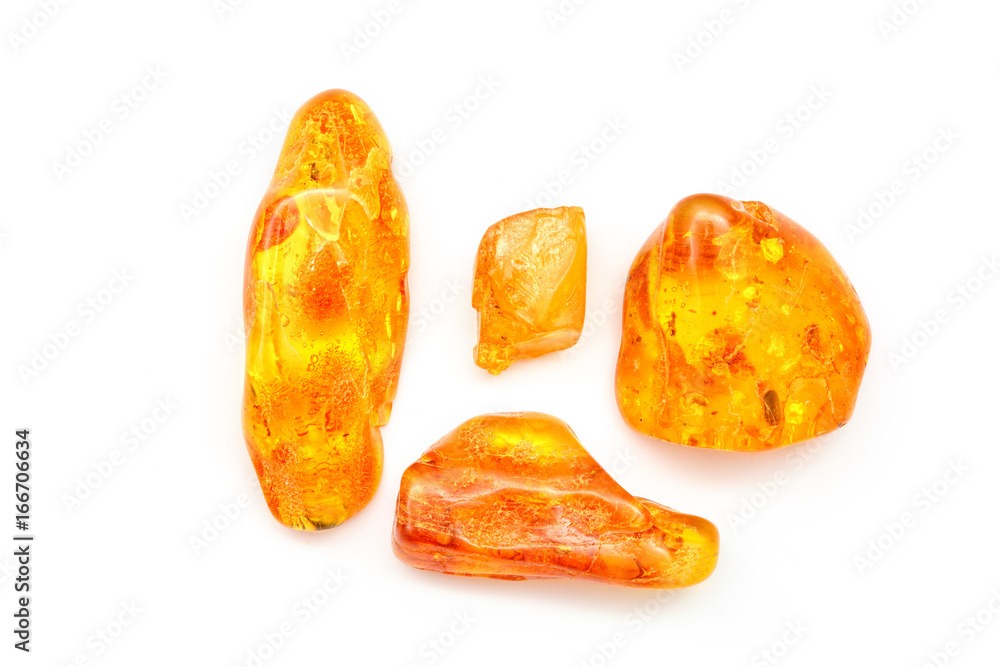 Amber. Bright yellow pieces of amber on a white background. Sunstone as a  precious stone. Mineral for jewelry. Vintage ancient resin. Baltic amber.  Colored bright pieces of amber resin. Top view Stock