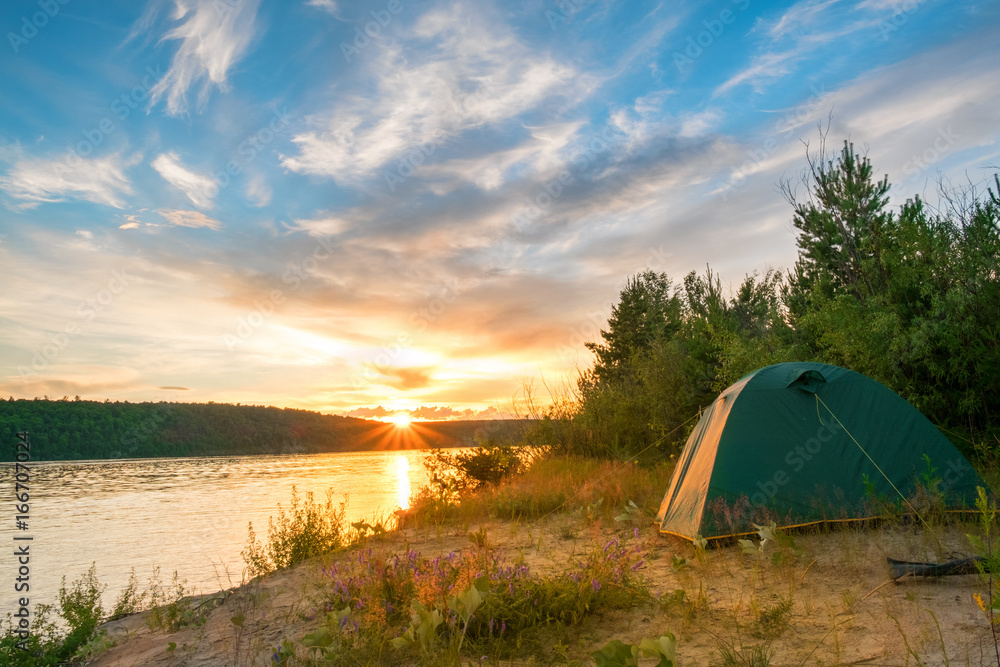 tourist tent stands on the banks of the river in the morning or evening