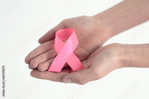 Hands presenting pink ribbon