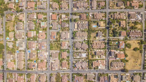 Vista aerea ortogonale di una parte del quartiere Marco Simone nella periferia nord a Roma. Tra le strade strette  le ville e i palazzi si vedono alberi. Sugli edifici ci sono antenne e parabole.