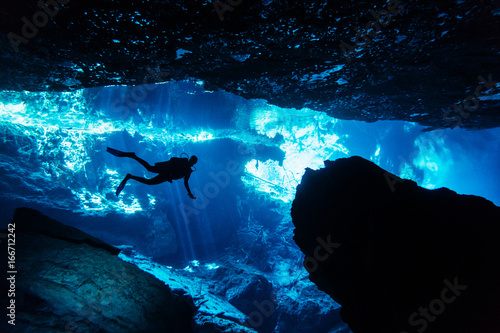 Silhouette of scuba diver exploring an underwater cave in a cenote in Yucatíçn Peninsula, Mexico photo