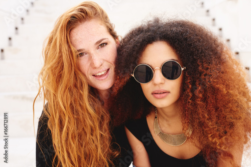 Redhed freckled woman with her afro friend photo