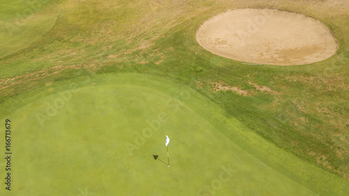 Vista aerea della buca finale del percorso di un campo di golf. Il prato fa parte di un ampio e ricco circolo di golf italiano frequentato dai migliori giocatori del panorama sportivo.