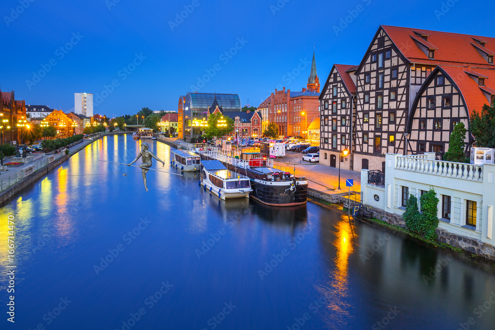 Architecture of Bydgoszcz city with reflection in Brda river at night, Poland
