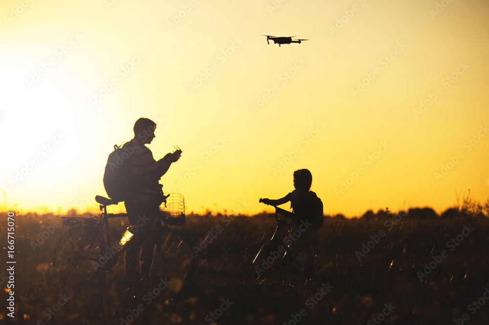 Young man operating of flying drone the setting sun Young man operating of flying drone the setting sun