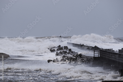    waves hitting against the pier during the storm in Nr. Vorupoer on the North Sea coast in Denmark            