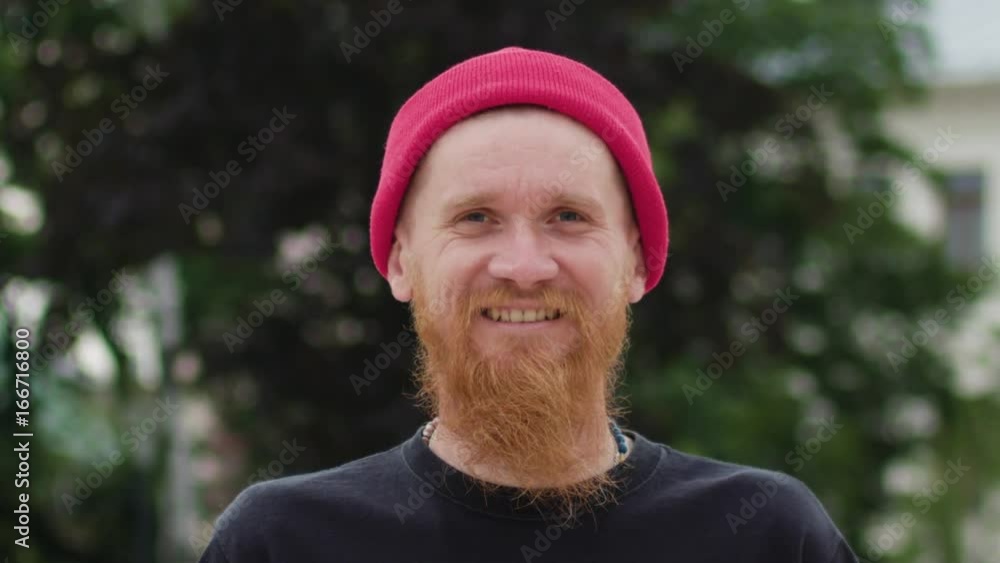 Young readhead hispter with beard and moustaches in jeans and T-shirt laughs suddenly. Outdoor. Cloudy. Medium. Stabilised. Portrait Young readhead hispter with beard and moustaches in jeans and T-shirt laughs suddenly. Outdoor. Cloudy. Medium. Stabilised. Portrait