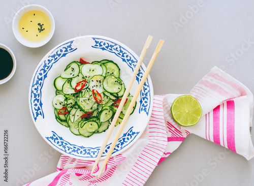 Thai salad of cucumber, dressing for salad, ricin vinegar, spices, bright cloth. Top view