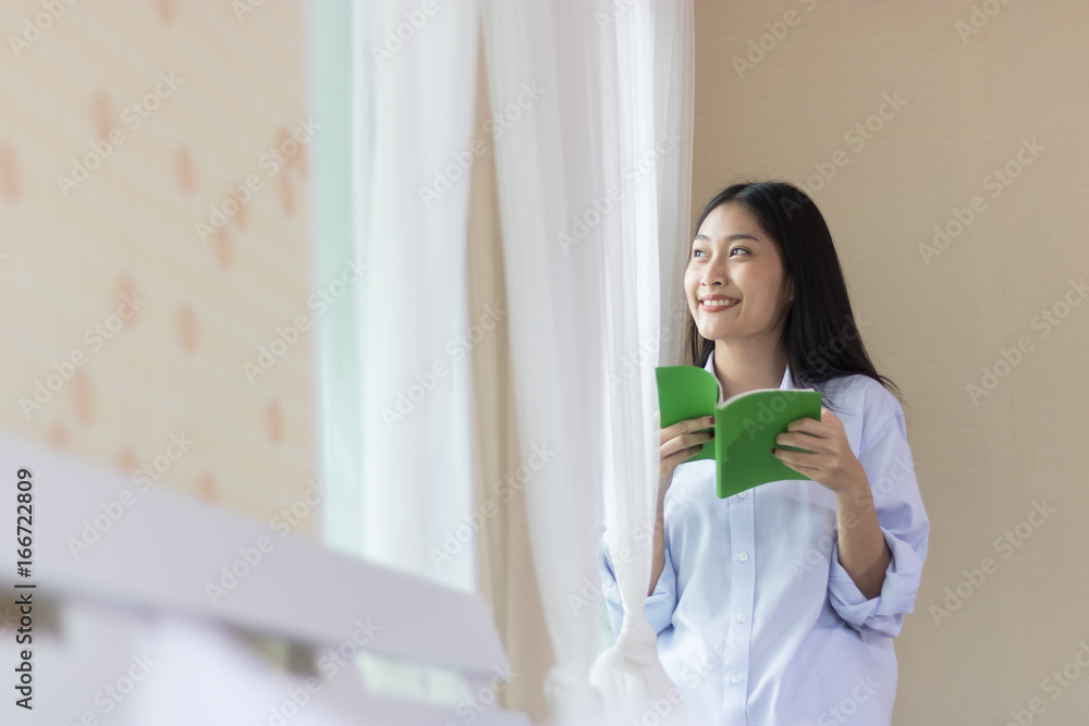 Asian Beautiful Woman Reading and relaxing at the window. Asian Beautiful Woman Reading and relaxing at the window.