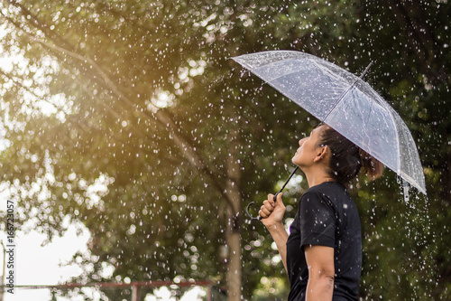 Asian woman under an umbrella in the rain.