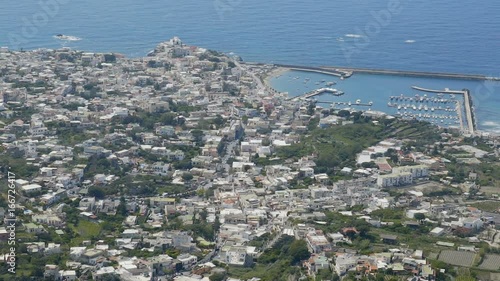 Picturesque coastal town lying at harbor with docked boats calm blue sea at back photo