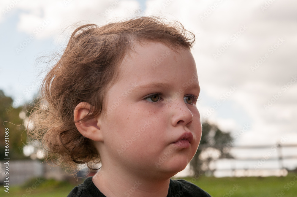 Young girl outside looking over at pumpkin fields Young girl outside looking over at pumpkin fields