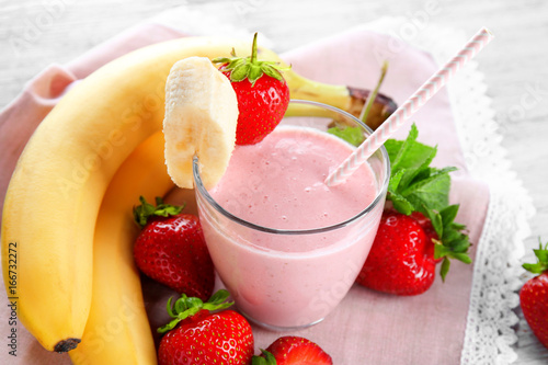Glass of delicious strawberry and banana homemade smoothie on napkin