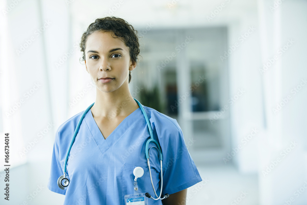 Portrait of confident, happy female nurse in hospital hallway Portrait of confident, happy female nurse in hospital hallway