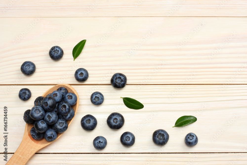 blueberries in wooden spoon on light wooden table background. top view with copy space blueberries in wooden spoon on light wooden table background. top view with copy space