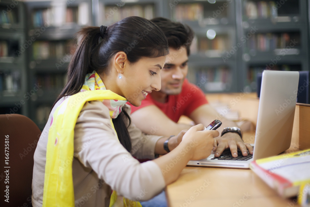 College student looking at sms on mobile phone College student looking at sms on mobile phone