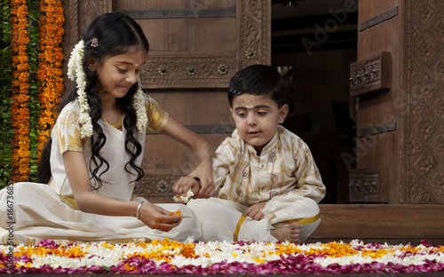 South Indian girl helping her brother with a rangoli  photo
