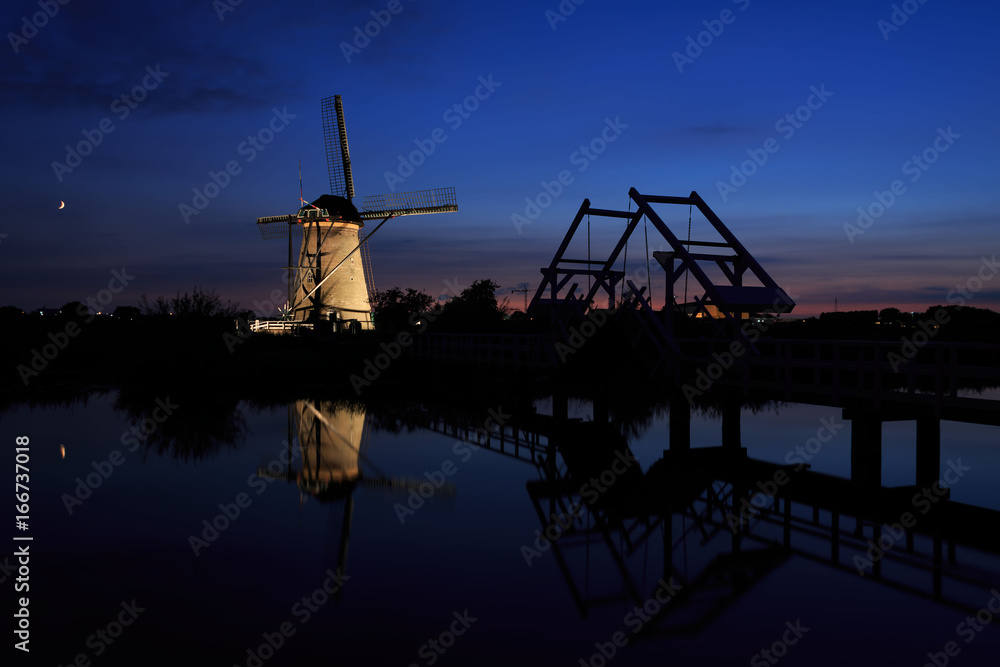Illuminated windmill and a drawbridge at sunset Illuminated windmill and a drawbridge at sunset
