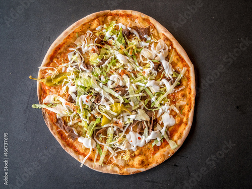 Kebab pizza on dark rustic background. Top view from above.