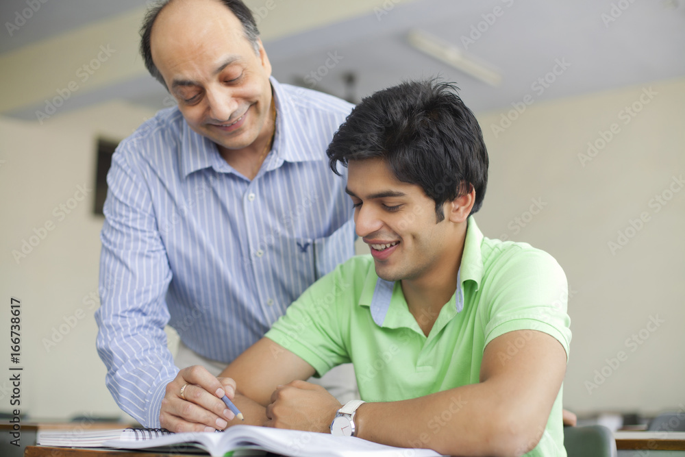 Teacher assisting student in classroom Teacher assisting student in classroom