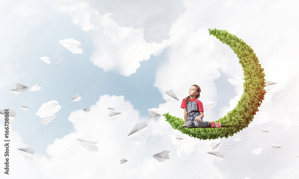 Concept of careless happy childhood with girl on green moon Concept of careless happy childhood with girl on green moon