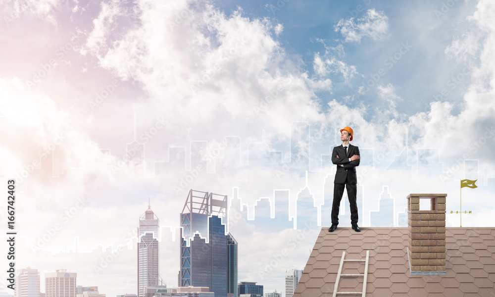 Engineer man standing on roof and looking away. Mixed media Engineer man standing on roof and looking away. Mixed media