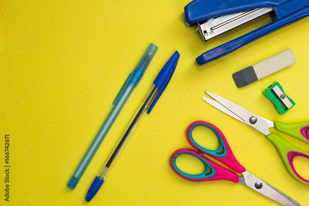 School accessories on a yellow background. Scissors, pens, sharpener, stapler. School accessories on a yellow background. Scissors, pens, sharpener, stapler.