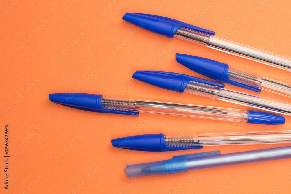 School accessories, blue pens on an orange background. School accessories, blue pens on an orange background.