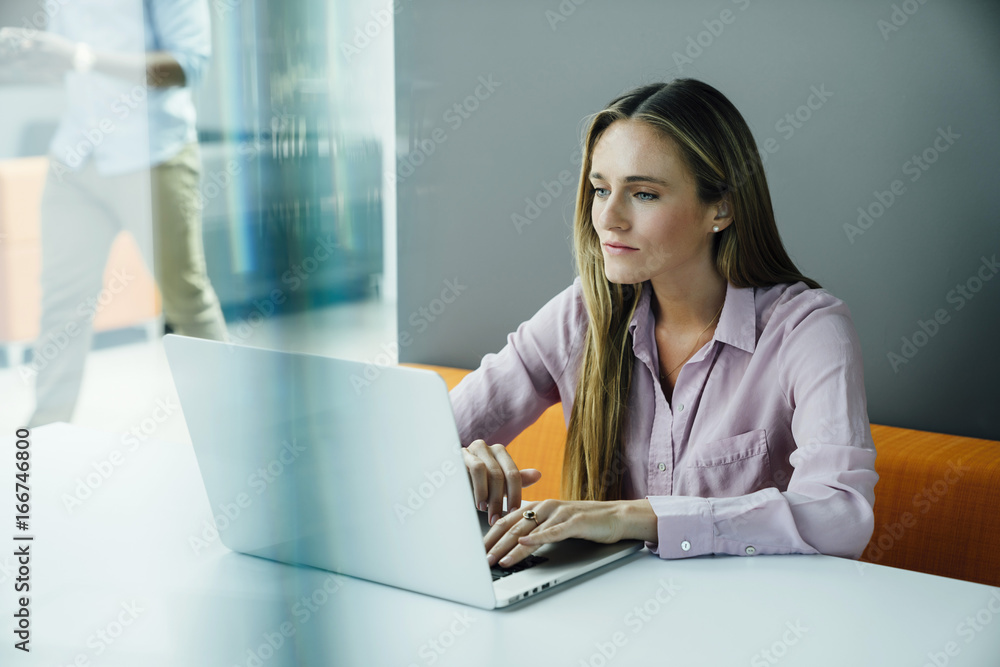 Business woman working on laptop computer in modern office space Business woman working on laptop computer in modern office space